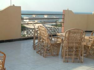 a group of chairs and tables on a balcony with the ocean at Diana Hotel Hurghada in Hurghada