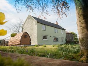 a large white house with a barn in front of it at Westmains Farm in Penton