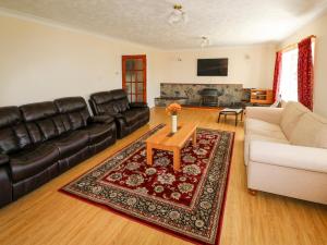 a living room with a couch and a table at Anglesey White Haven in Llandegfan