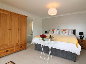 Un dormitorio con una cama y una mesa con flores. en Omalast, en Truro