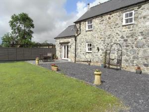 a stone house with a garden and a patio at Y Bwythyn at Henfaes in Rhydymain