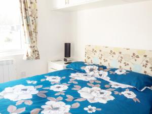 Llaninaにある73-The Lodgeのベッド(白い花の上に青い毛布付)