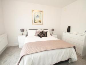 a white bedroom with a bed and white cabinets at 5 Arlington Villas in Ilfracombe