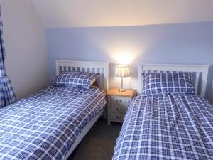 sypialnia z 2 łóżkami i lampką na stoliku nocnym w obiekcie Amelia Cottage w mieście Battle