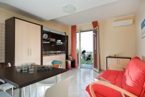 a living room with a red couch and a table at Casa Vacanze Samira in Fondachello