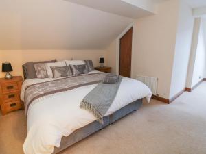 a bedroom with a large bed with white sheets at Hill Bank in Lupton
