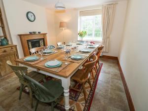 a dining room table with chairs and a clock on the wall at Town Mill in Bewdley