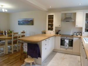 a kitchen with a table and a dining room at Eribel Cottage in Threlkeld