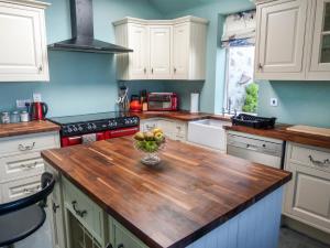 a kitchen with a wooden counter top with a bowl of fruit at 5 Distillery Cottages in Whitehills