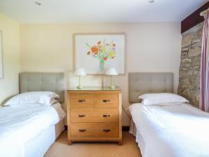 ein Schlafzimmer mit 2 Betten und einer Vase aus Blumen in der Unterkunft Flower House in Saint Erth