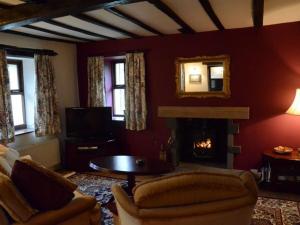 a living room with a couch and a fireplace at Greety Gate House in Duddon