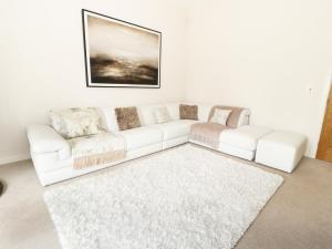 um sofá branco numa sala de estar com um tapete em Bell House Barn em Staindrop