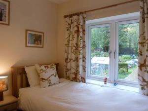 una camera da letto con un letto e una grande finestra di Eribel Cottage a Threlkeld