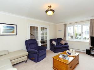 a living room with two blue chairs and a coffee table at Glebe House in Aveton Gifford