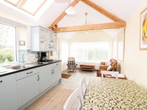 a kitchen with white cabinets and a table and a dining room at Simmer Dim in Kirkbean