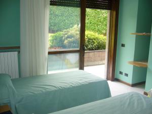 1 dormitorio con cama y ventana grande en The Flower Garden, en Scanzorosciate