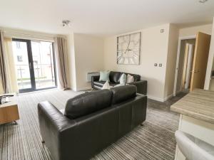 a living room with a black leather couch at 5 Windermere in Stourport