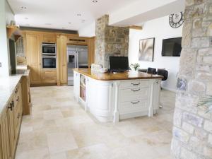uma grande cozinha com uma parede de pedra e um balcão em Bell House Barn em Staindrop