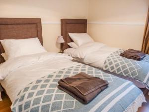 duas camas individuais com toalhas por cima em 5 Distillery Cottages em Whitehills
