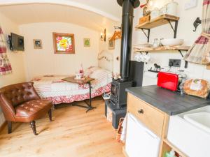 a kitchen with a bed and a stove in a room at The Clydes in Tremeirchion