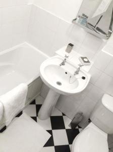 a white bathroom with a sink and a toilet at The Feversham in York +4 photos