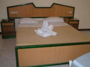 een groot bed met een witte handdoek erop bij Diana Hotel Hurghada in Hurghada