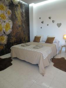 Un dormitorio con una cama y una pared con flores. en Golden Dreams & Perfect for you *****, en Adeje