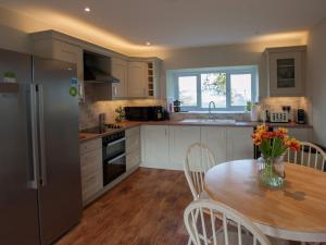 a kitchen with a table with a vase of flowers on it at Westmains Farm in Penton