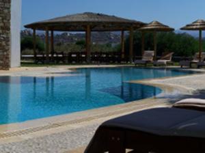 uma grande piscina com guarda-sóis e cadeiras em Plaka Hotel II em Plaka