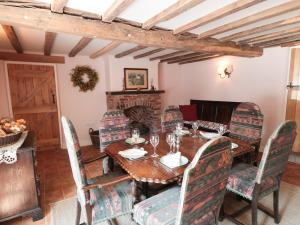 a dining room with a table and chairs and a fireplace at Just A Cottage, Newlands Farm in Swanwick