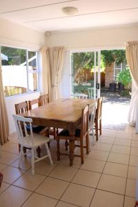 a dining room with a wooden table and chairs at Sandpiper Cottage in Kleinemonde