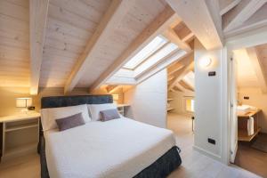 een slaapkamer met een bed in een kamer met houten plafonds bij Liszt Attic by KlabHouse in Bellagio