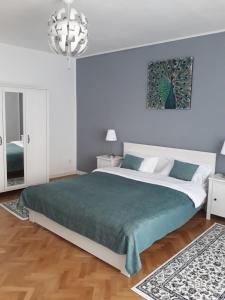 een slaapkamer met een groot bed en een kroonluchter bij Apartment Bianco Central in Sibiu