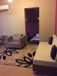ein Wohnzimmer mit einem Sofa und einem Stuhl in der Unterkunft Kanaan Group Hotel in Baalbek