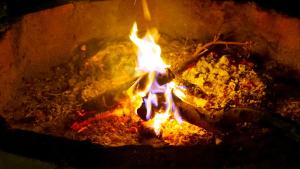 Un fuoco brucia in un focolare di PrideInn Mara Camp & Cottages a Talek
