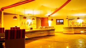 a restaurant with a bar in a yellow room at PrideInn Mara Camp & Cottages in Talek
