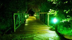 a wooden bridge at night with a light on it at PrideInn Mara Camp & Cottages in Talek