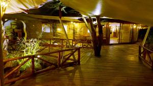 a porch of a building with a table and fence at PrideInn Mara Camp & Cottages in Talek