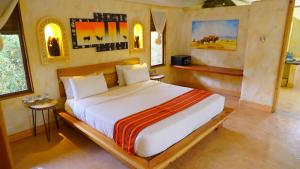 a bedroom with a large bed in a room at PrideInn Mara Camp & Cottages in Talek