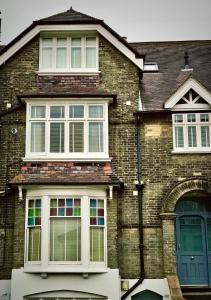 una casa in mattoni con due finestre e una porta blu di Flat 4, York Terrace a Norwich
