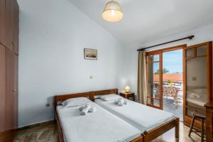 a bedroom with a bed and a balcony at Areti Apartments in Póros Kefalonias