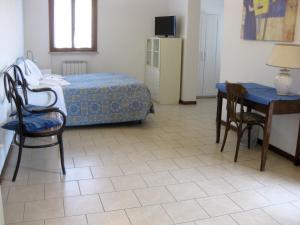 een slaapkamer met een bed en een tafel en stoelen bij Country House-B&B-Appartamenti Ai Cipressi in Urbino
