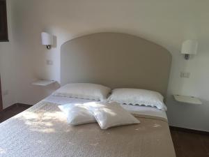 Una cama blanca con dos almohadas encima. en B&B La Quiete en Massa Lubrense