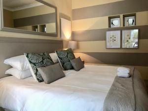Johannesburg的住宿－第三生命酒店，一张带枕头和镜子的大型白色床