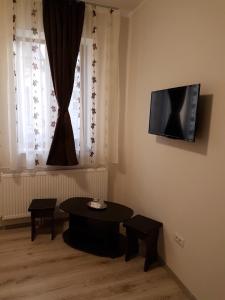 sala de estar con mesa y TV en la pared en Casa Stefan Galati en Galaţi