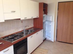 a kitchen with a sink and a stove and a refrigerator at Cordovena in Capo dʼOrlando