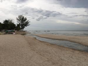 een zandstrand met boten in het water bij Mida de Sea Residence Hua Hin in Cha Am