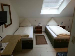 two beds in a small room with a window at Hotel Am Kamin - Modern Appartements - Free Wifi - Parking in Duisburg