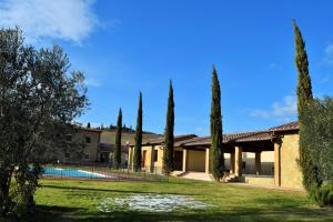 a house with a pool and trees in the yard at Le Checche in Pienza