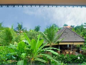 um edifício de resort com cadeiras e palmeiras em Bucu Guest House em Ubud